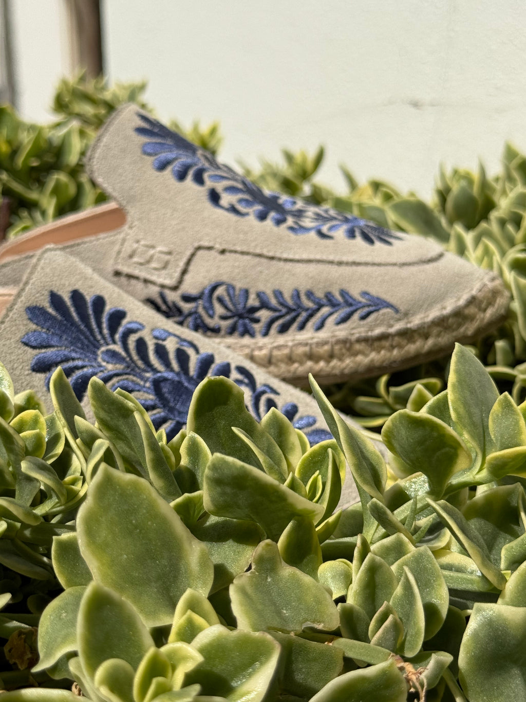 Detalle de costura y bordado artesanal azul sobre lino premium, calzado exclusivo y atemporal de marca slow fashion ESPARTINAS. Hecho en España, zapatos estilo veneciana o slipper.